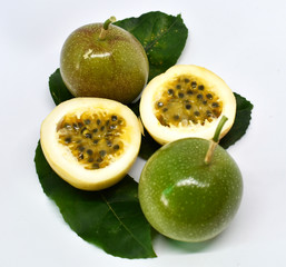 Passion fruit, halved and the leaves are arranged isolated on a white background.