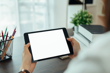 Closeup of woman hand holding digital tablet on the table and the screen is blank.