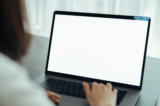 Woman had using laptop white screen and stationery on the table.