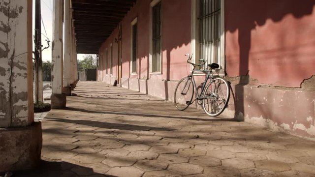 old red colonial house with a track bike leaning against the wall