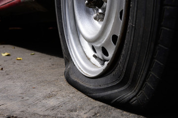 Selective focus flat tire of old car park on the street