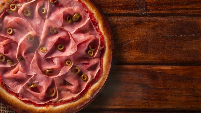 Brazilian pizza with mortadella and green olive. Top view on wood background, close up. Traditional Brazilian Pizza with smoke.