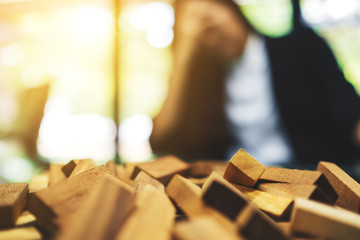 Businesswoman get stressed while having a problem at work in office with wooden blocks of Tumble...