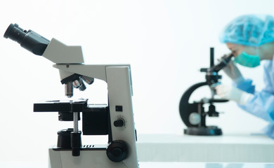 female doctor analyzing virus and light microscope close-up