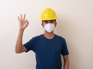 Asian industrial workers wear yellow hard hats, wear protective masks for their healtha