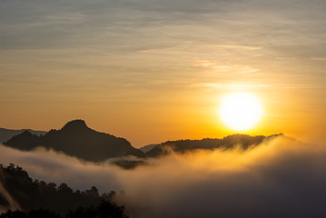Sunrise and morning light behind the mountains with the mist covered.