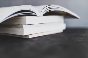 stack of books with one open on top of themshot from eye level with shallow depth of field