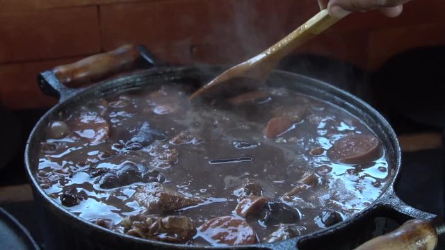The national dish of Brazil - "Feijoada" being prepared in a cast iron pot. 