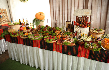 Buffet table with meat, sir, drinks, cowboy.