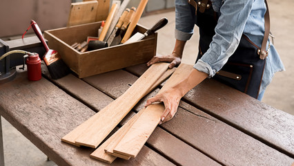 Carpenter working with equipment on wooden table in carpentry shop. woman works in a carpentry shop.