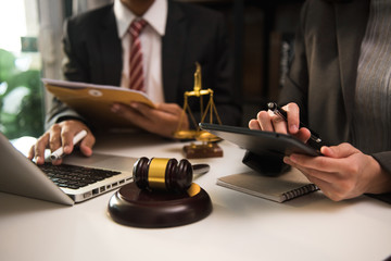 Business and lawyers discussing contract papers with brass scale on desk in office. Law, legal services, advice,  justice and law concept .