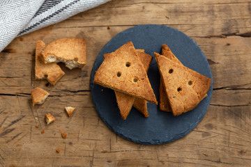 Shortbread biscuit on black stone plate, flat lay