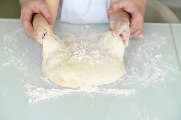 hands of a child and dad cook from dough