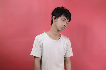 Sleepy young Asian man. Asian men wearing white t shirts isolated on a red background