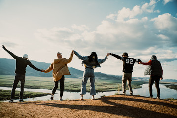group of people holding hands on a hill