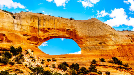 Wilson Arch under blue sky, a sandstone arch along US Highway 191, south of the town of Moab in Utah, United States