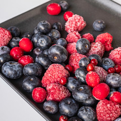 wildberies, raspberries and blackberries on black plate