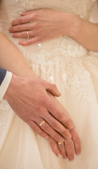 Hand of the groom on the bride's hand. Wedding day.