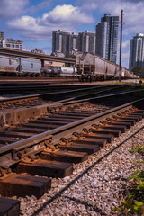 Fototapeta premium Railway yard in the city with tall buildings in the background.
