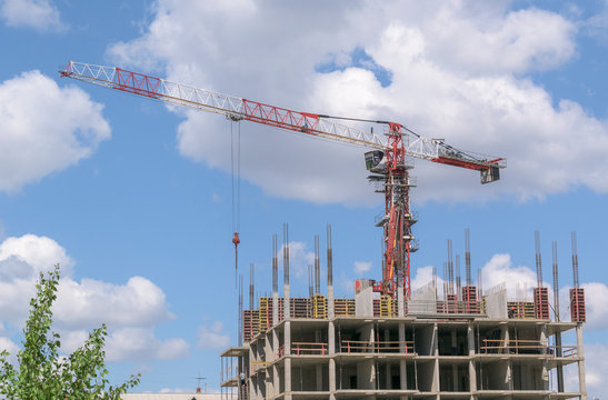 Building a house using Cast-in-place concrete. High-altitude crane. Concrete formwork pumping device. Metal fittings stick out in walls and columns. Concept of construction business.