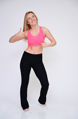 Fototapeta na wymiar A slender Caucasian model poses in various poses with a smile. Portrait of a pretty fitness blonde girl in a sports uniform on a white background in full growth.