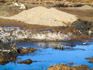 Piles of melting snow. Melting snow on the street. Dirty snow. Spring landscape. Puddle. Clay soil