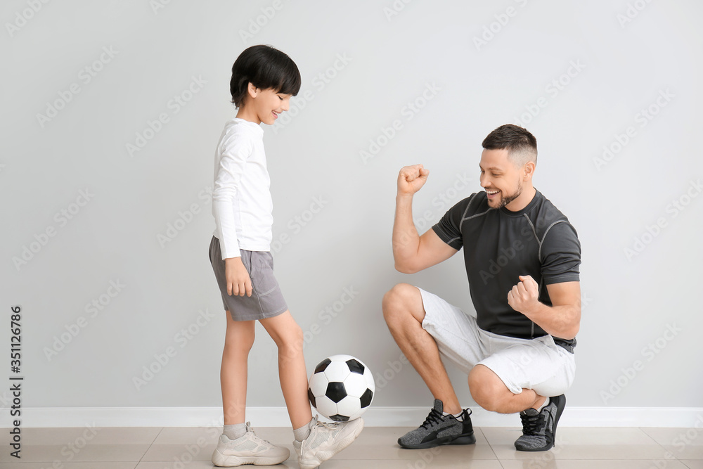 Canvas Prints father and little son with soccer ball near grey wall