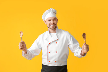 Naklejka premium Portrait of male chef on color background