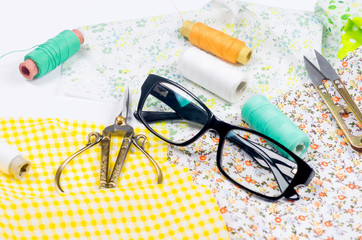 Sewing set with fabric, spools of thread, scissors and glasses