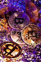 Many gold coins Bitcoin with blue and yellow light. Many nice reflections. Close-up shot