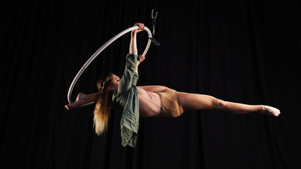 Professional circus aerialist performs splits on the ring. young, athletic, flexible gymnast on a...
