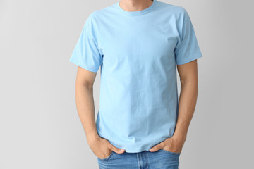 Man in stylish t-shirt on grey background