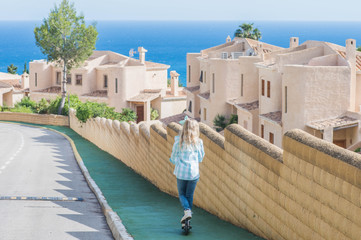 Active little girl with scooter  in park outdoors on summer day.  Summer time fun