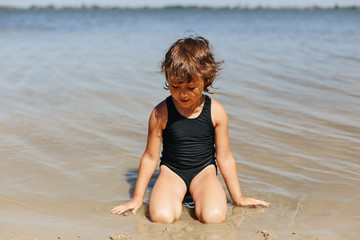 Cute little girl playing jumping in water, happy child having fun