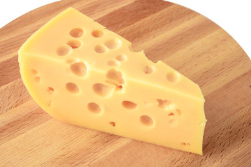piece of cheese with holes on a wooden board, triangular cheese piece