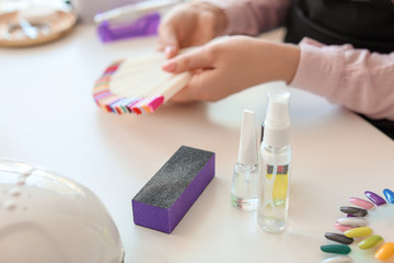 Obraz na płótnie Canvas Bottles with cosmetics and nail file on table in beauty salon