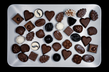Traditional Turkish Candies designed on black surface with chocolate.Conceptual image of celebrations. Close-up chocolate. Religious Holiday, The Sugar Feast After Ramadan. Top view.
