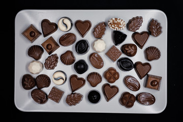 Traditional Turkish Candies designed on black surface with chocolate.Conceptual image of celebrations. Close-up chocolate. Religious Holiday, The Sugar Feast After Ramadan. Top view.
