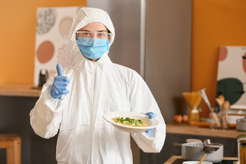 Woman in biohazard suit cooking in kitchen
