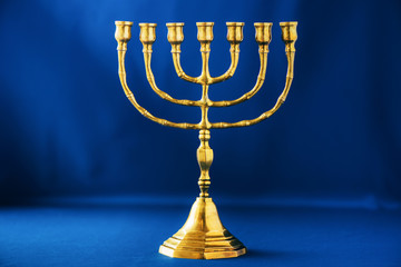 Golden hanukkah menorah on blue background. Jewish holiday banner with copy space. Ancient ritual...