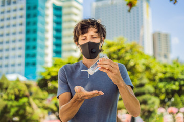 COVID-19 Pandemic Coronavirus. man hands using wash hand sanitizer gel, against novel coronavirus 2019-nCoV or COVID 19 in city street. Antiseptic, Hygiene and Healthcare