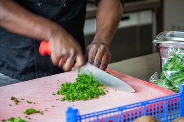 african american cutting vegetables in restaurant commercial kitchen

