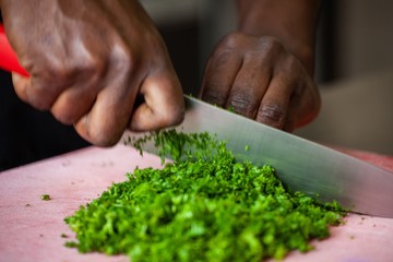african american cutting vegetables in restaurant commercial kitchen
