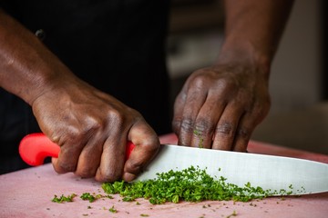 african american cutting vegetables in restaurant commercial kitchen
