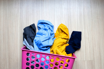 Clothes in pink plastic laundry basket.