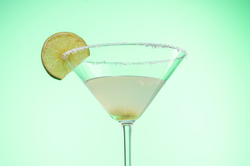 margarita cocktail in martini glass on a light green background