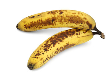 two brown spotted, overripe bananas on white background