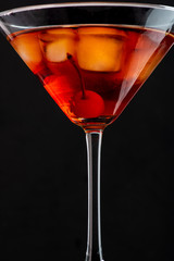 manhattan cocktail in martini glass on dark background