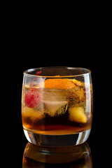 old fashion cocktail in a glass of rox on a black background