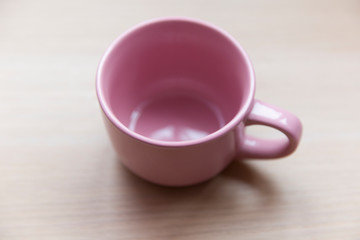 Pink empty ceramic mug on the table.